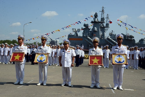 Chuẩn Đô đốc Mai Tiến Tuyên trao quốc kỳ và hải kỳ cho thuyền trưởng, chính trị viên hai tàu. Ảnh: QĐND