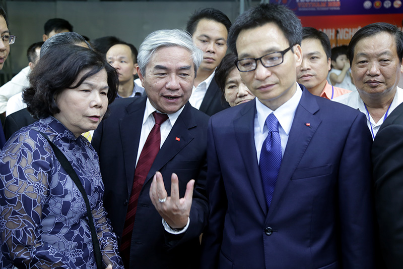 Phó Thủ tướng Vũ Đức Đam (phải), Bộ trưởng Nguyễn Quân (giữa) và bà Kim Hạnh đi tham quan các gian hàng tại Techmart 2015. Ảnh: Lê Loan