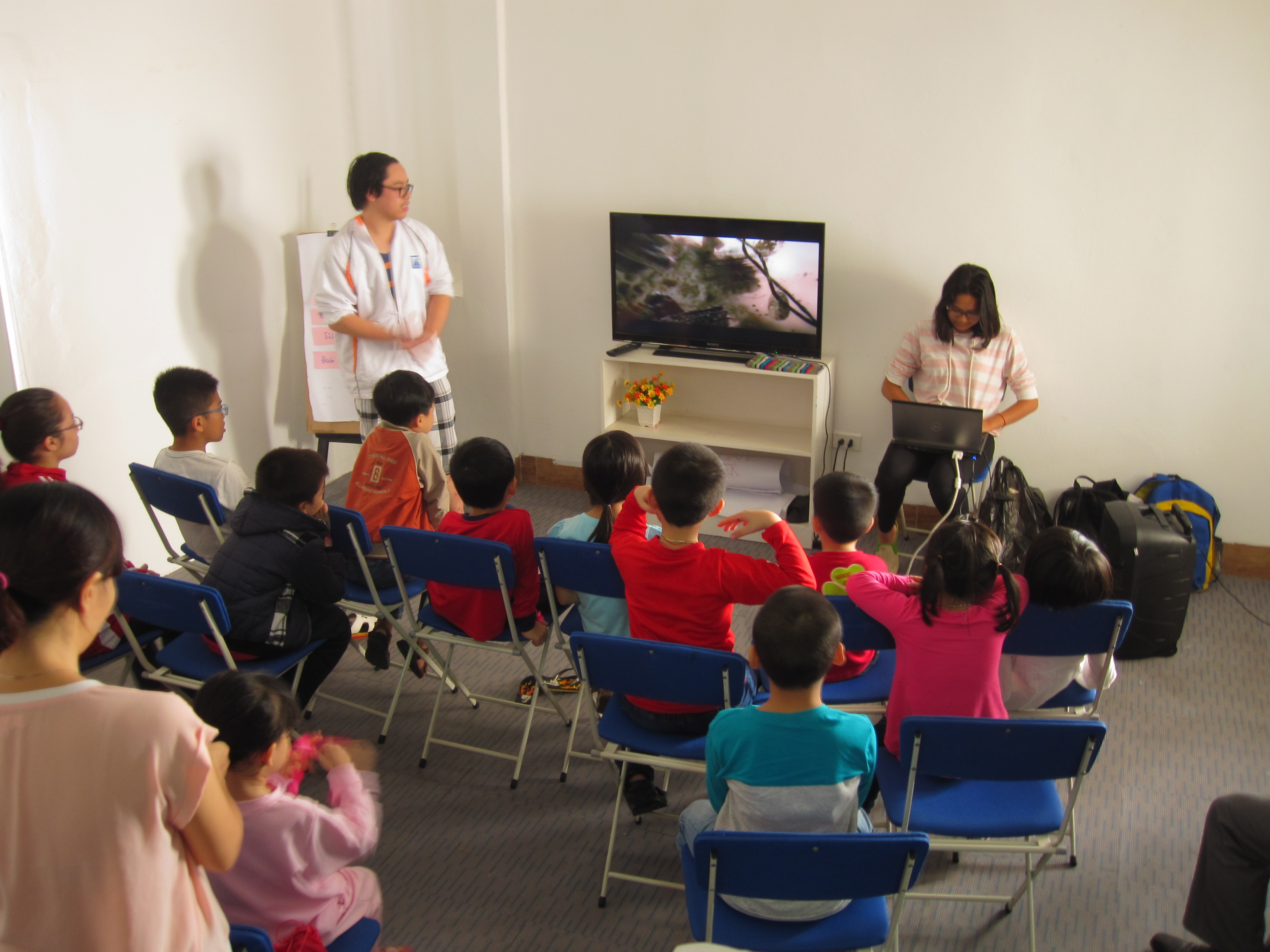 Các bé chăm chú xem phim và nghe giải thích về cấu tạo của gen và tế bào.