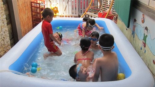 Các em nhỏ vui chơi trong bể bơi tại nhà.
