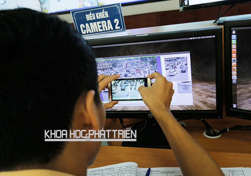 Cán bộ Trung tâm Điều khiển đèn tín hiệu giao thông Hà Nội đang chụp màn hình các vi phạm giao thông gửi qua điện thoại cho các cảnh sát ở gần địa bàn vi phạm. Ảnh: Lê Loan