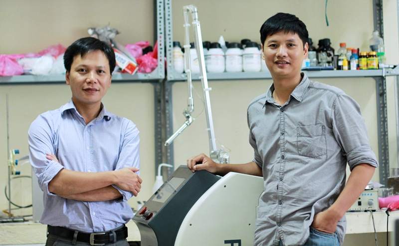 TS Đỗ Hoàng Tùng (phải) và TS Nguyễn Thế Anh bên cạnh chiếc máy PlasmaMed do chính 2 anh chế tạo. (Ảnh: Lê Văn).