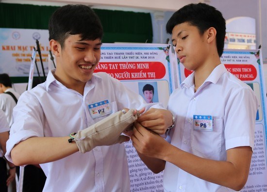 Lê Ngô Duy Phong (bên trái) đang hướng dẫn sử dụng găng tay thông minh. (Nguồn: Husta.org)
