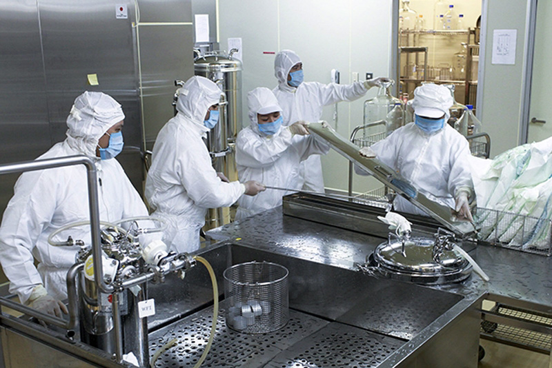 Các cán bộ kỹ thuật làm việc trong dây chuyền sản xuất vắc-xin sởi-rubella.