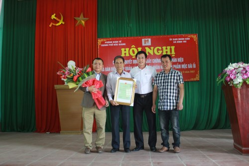 Cán bộ Sở K&CN Bắc Giang trao chứng nhận nhãn hiệu tập thể Mộc Bãi Ổi cho HTX Mộc Bãi Ổi.