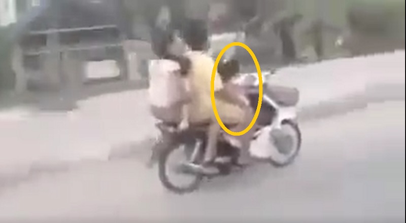 Cận cảnh bé gái 3 tuổi chở 3 người trên chiếc xe máy.