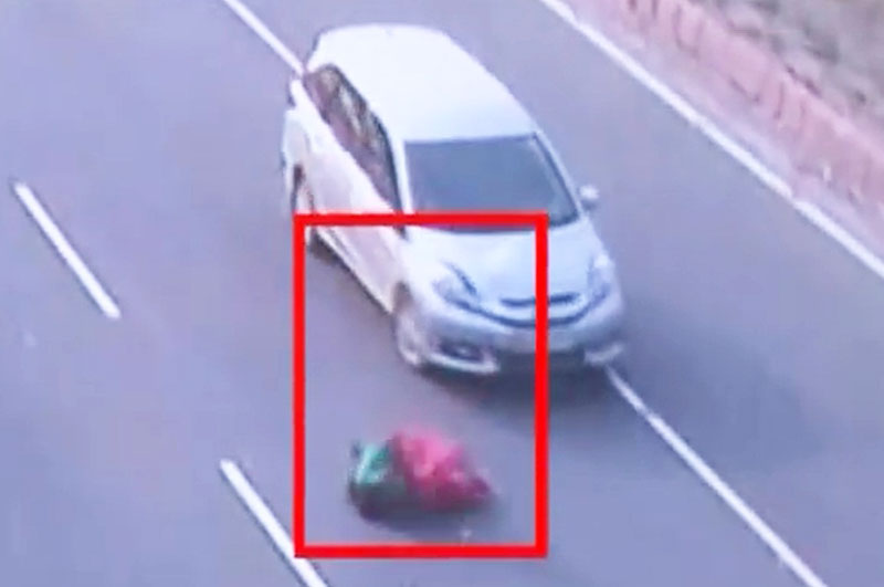Người phụ nữ nằm trên đường sau khi bị xe hơi tông.