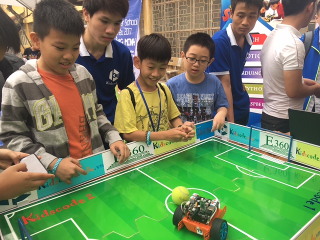 Điều khiển robot để tham gia một trò chơi đá bóng thu hút các bạn học sinh tiểu học.