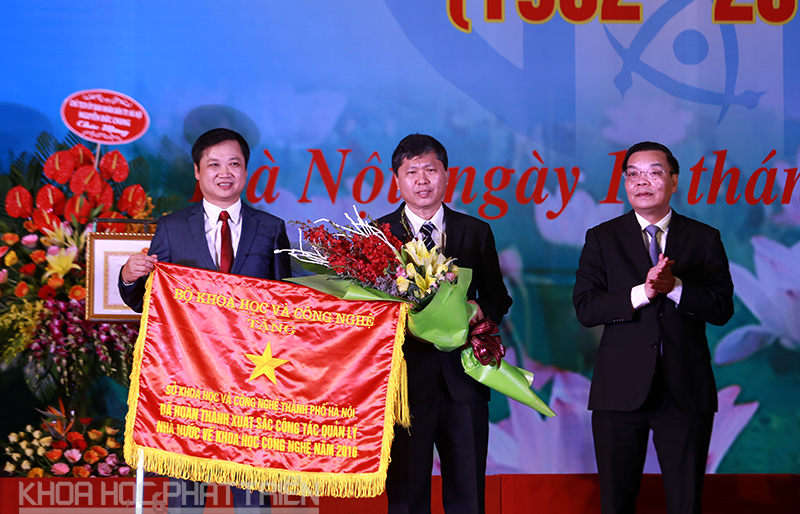 Ông Chu Ngọc Anh  (bên phải, ngoài cùng) trao cờ thi đua của Bộ KH&CN cho sở KH&CN Hà Nội. Ảnh: Lê Loan