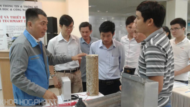 Ông Lê Trung Hiếu (trái) giới thiệu về công nghệ xử lý cáu cặn không dùng hóa chất