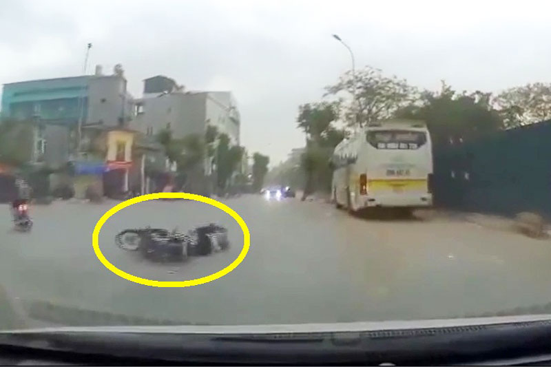 Người đàn ông chạy xe máy ngã nhào xuống đường.
