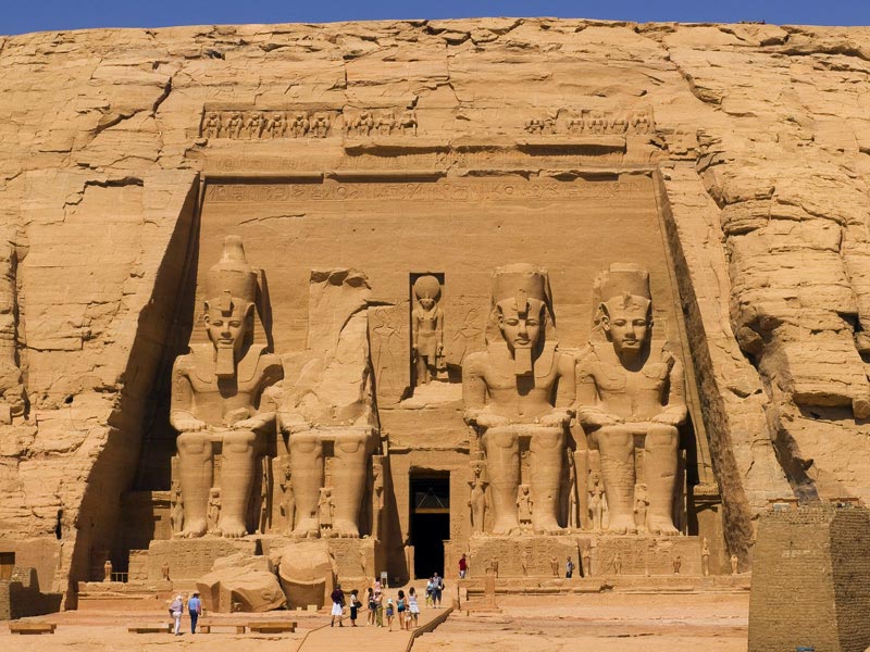 3. Đền Abu Simbel. Khu khảo cổ bao gồm hai ngôi đền lớn tạc từ đá nằm tại phía Nam Ai Cập, về phía Tây hồ Nasser và khoảng 290 km về phía Tây Nam của Aswan. Ngoài các vách tường ở sân trong, bên ngoài và một ngôi nhà thờ Mặt Trời nhỏ, toàn bộ ngôi đền đều được tạc từ đá rắn. Nhờ vào sự hẻo lánh và vững chãi, ngôi đền được bảo quản tốt, bất chấp nước trong đập Aswan dâng cao. Chiếm cả mặt tiền là bốn pho tượng khổng lồ của nhà vua, cao khoảng 22m trong khi lối vào giữa các tượng dẫn đến một loạt các phòng trong khoét sâu vào trong vách đá.