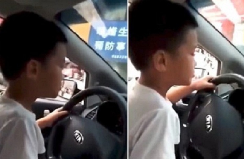 Cậu bé 6 tuổi ngồi trên lòng bố và không thắt dây an toàn khi lái xe.
