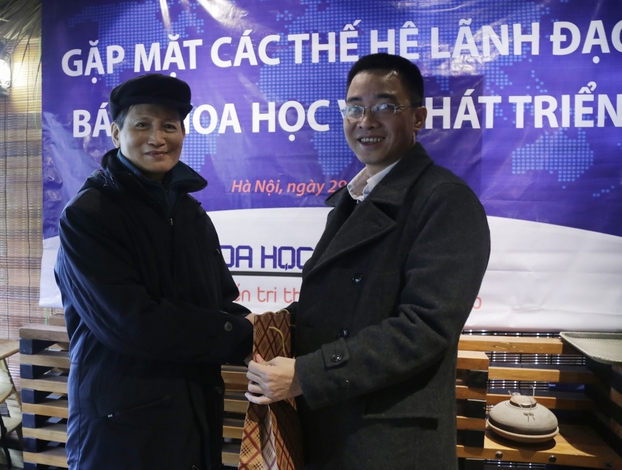 Phó Tổng biên tập Đỗ Lê Thăng (phải) trao quà cho nguyên Phó Tổng biên tập Nguyễn Chân Giác.