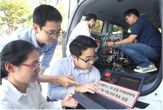 Các nhân viên LG U+ theo dõi kết quả của công nghệ ‘Kết nối kép’ trên một thiết bị đo kiểm trong một chiếc xe hơi tại trạm thu phát sóng thử nghiệm 5G
