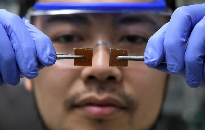 Nhà khoa học Yu Yanagisawa thí nghiệm ghép hai mảnh thủy tinh tự liền. (Nguồn: AFP/TTXVN)