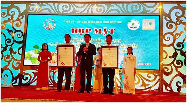 Đồng chí Đinh Hữu Phí trao Giấy chứng nhận đăng ký chỉ dẫn địa lý Dừa uống nước xiêm xanh và Bưởi da xanh cho Lãnh đạo tỉnh Bến Tre