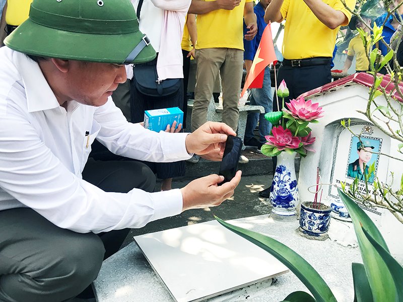 Bộ trưởng Bộ TT&TT Trương Minh Tuấn cùng tham gia trải nghiệm phần mềm chụp ảnh mộ liệt sĩ.