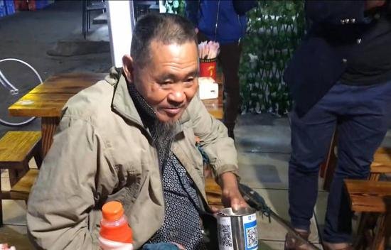 Một cụ ông với QR Code dán trên chiếc lon xin ăn - Ảnh: China Daily/Asia News Network