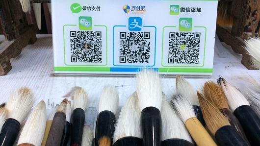 Một nơi bán bút lông có cả tài khoản WeChat (ngoài cùng bên trái), và tài khoản AliPay (ở giữa) cho khách tuỳ chọn cách trả - Ảnh: Evelyn Cheng/CNBC
