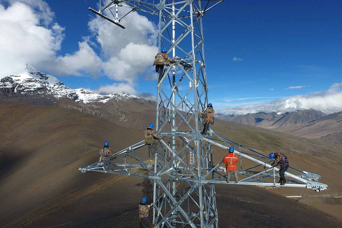 Công nhân Trung Quốc đang xây dựng tháp truyền tải điện ở độ cao 5.548 mét trên đỉnh Mengdala thuộc huyện Lạc Trát (Luozha), địa khu Sơn Nam (Lhoka), khu tự trị Tây Tạng. Ảnh: STR/AFP.