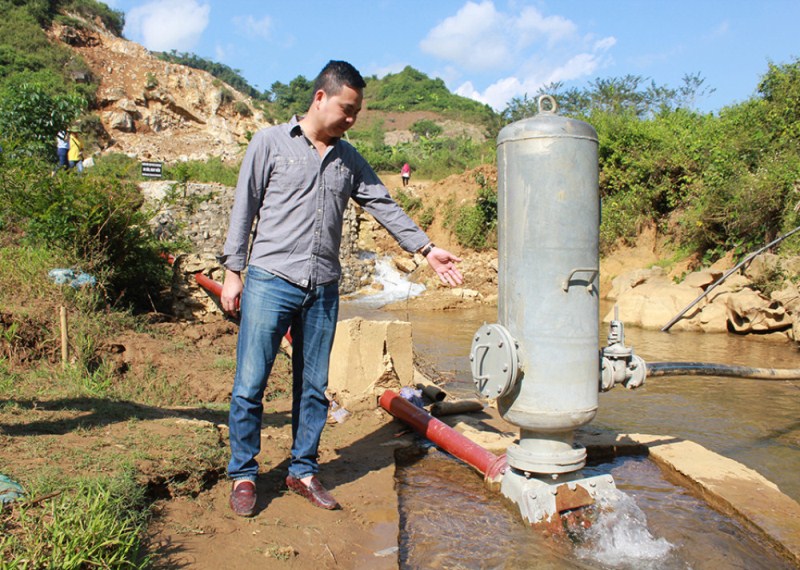 Một nhà nghiên cứu thuộc dự án giới thiệu bơm tự áp đưa nước từ suối về bể chứa ở trường. Ảnh: Minh Đức/Phụ nữ Việt Nam.