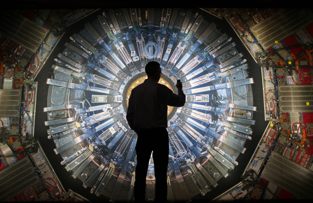 Một người đứng trước bức tranh máy gia tốc hạt tại Bảo tàng khoa học London. Ảnh: Genk