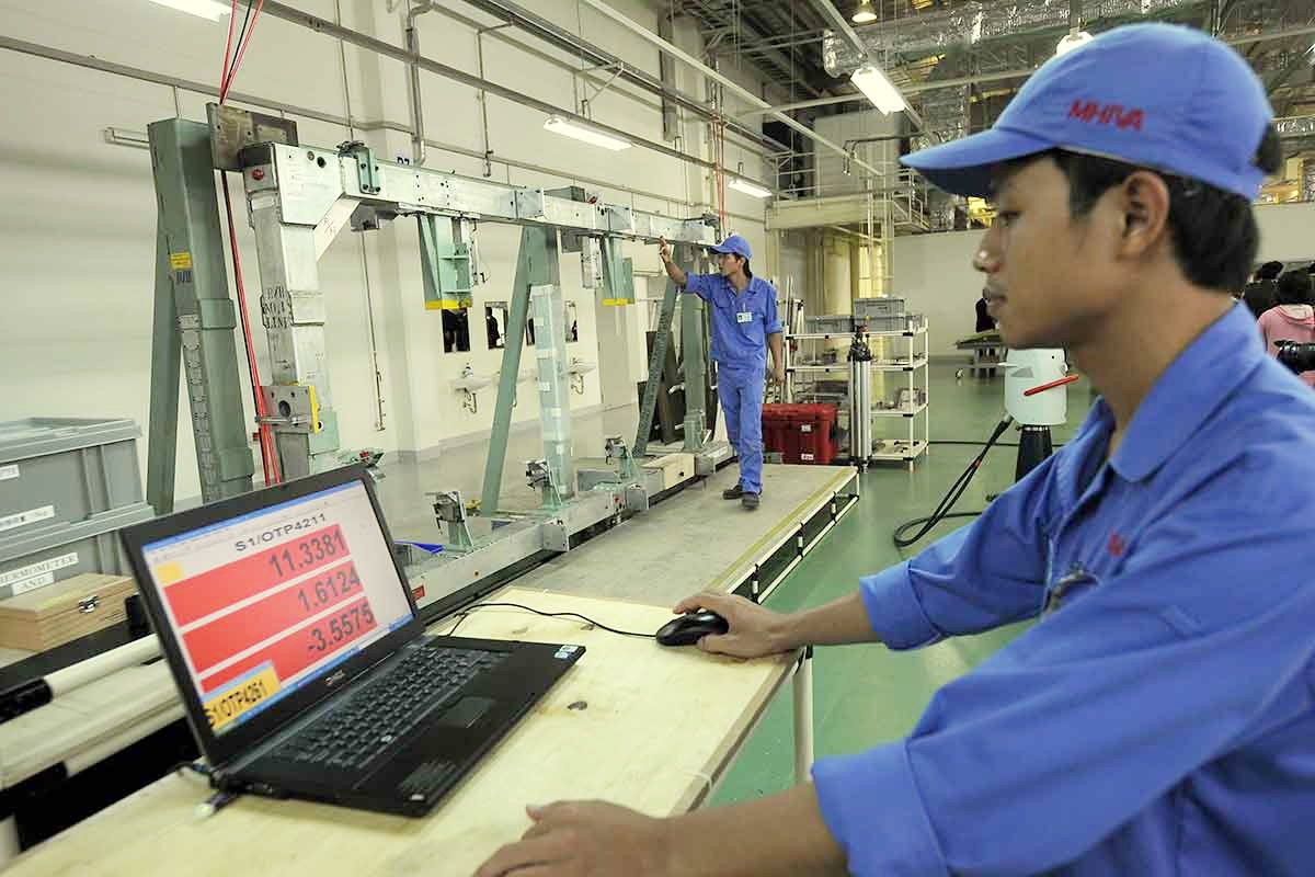 Kỹ thuật viên của Công ty Công nghiệp nặng Mitsubishi(MHI) đang làm việc tại dây chuyền sản xuất ở Khu công nghiệp Thăng Long, Hà Nội. Ảnh: AFP