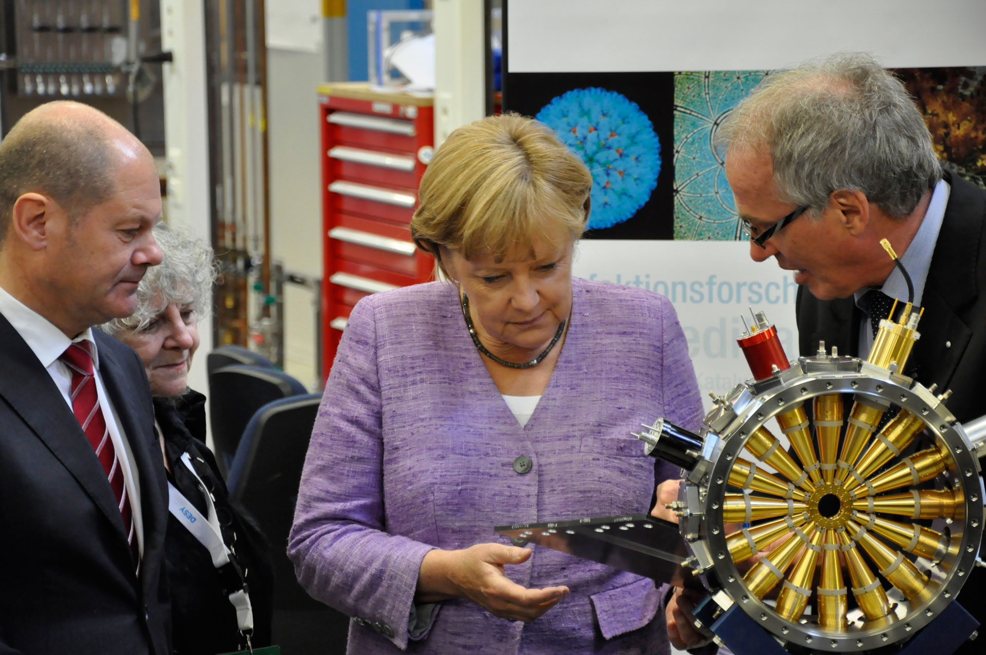 Giám đốc Trung tâm Máy gia tốc DESY Helmut Dosch giải thích về một thiết bị được sử dụng trong nghiên cứu về phóng xạ với Thủ tướng Đức Angela Merkel. Nguồn: Bundeskanzlerin