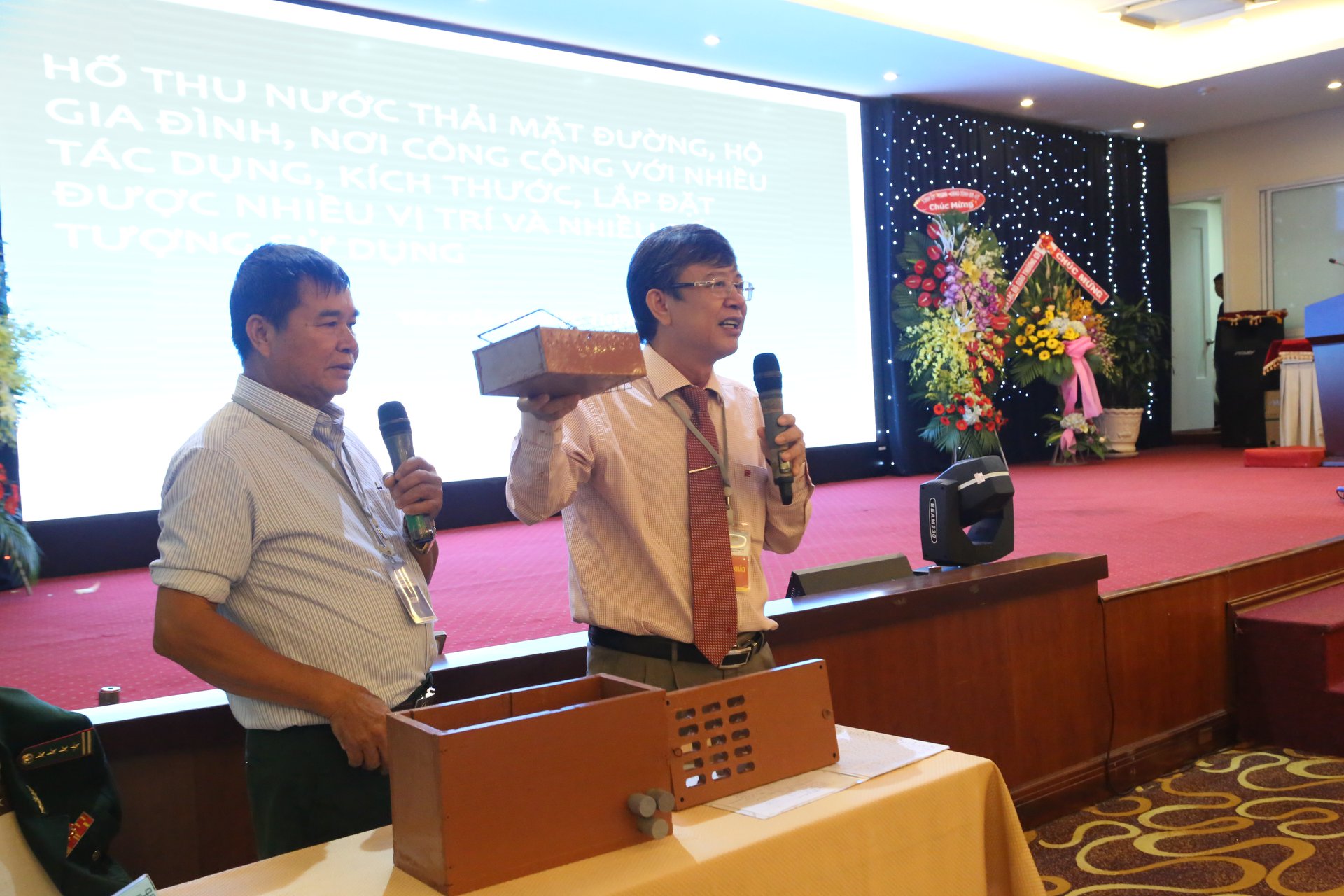Ông Mai Thanh Quang, giám đốc sở KH&CN Bà Rịa - Vũng Tàu (phải) giúp đại tá về hưu Bùi Đức Thịnh trong phần thi của mình. Ảnh: BTC