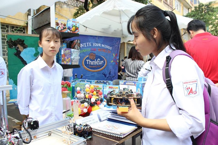 Tiêu Hồng Nhung (phải), HS lớp 11, trường THPT An Dương, huyện An Dương, Hải Phòng đang giải thích về quá trình thiết kế, lập trình hai robot dò đường và tránh vật cản trong ngày hội STEM 2018. Ảnh: Bảo Như.