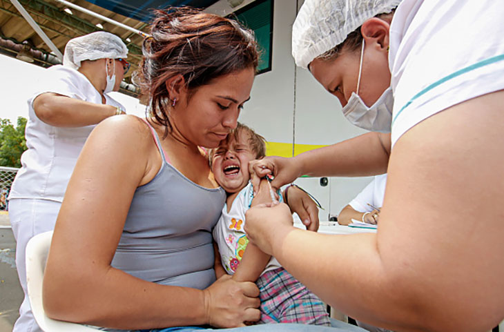 Một phụ nữ Venezuela và em bé được tiêm vắc-xin sởi khi họ đi qua biên giới tới Colombia vào tháng 3/2019.