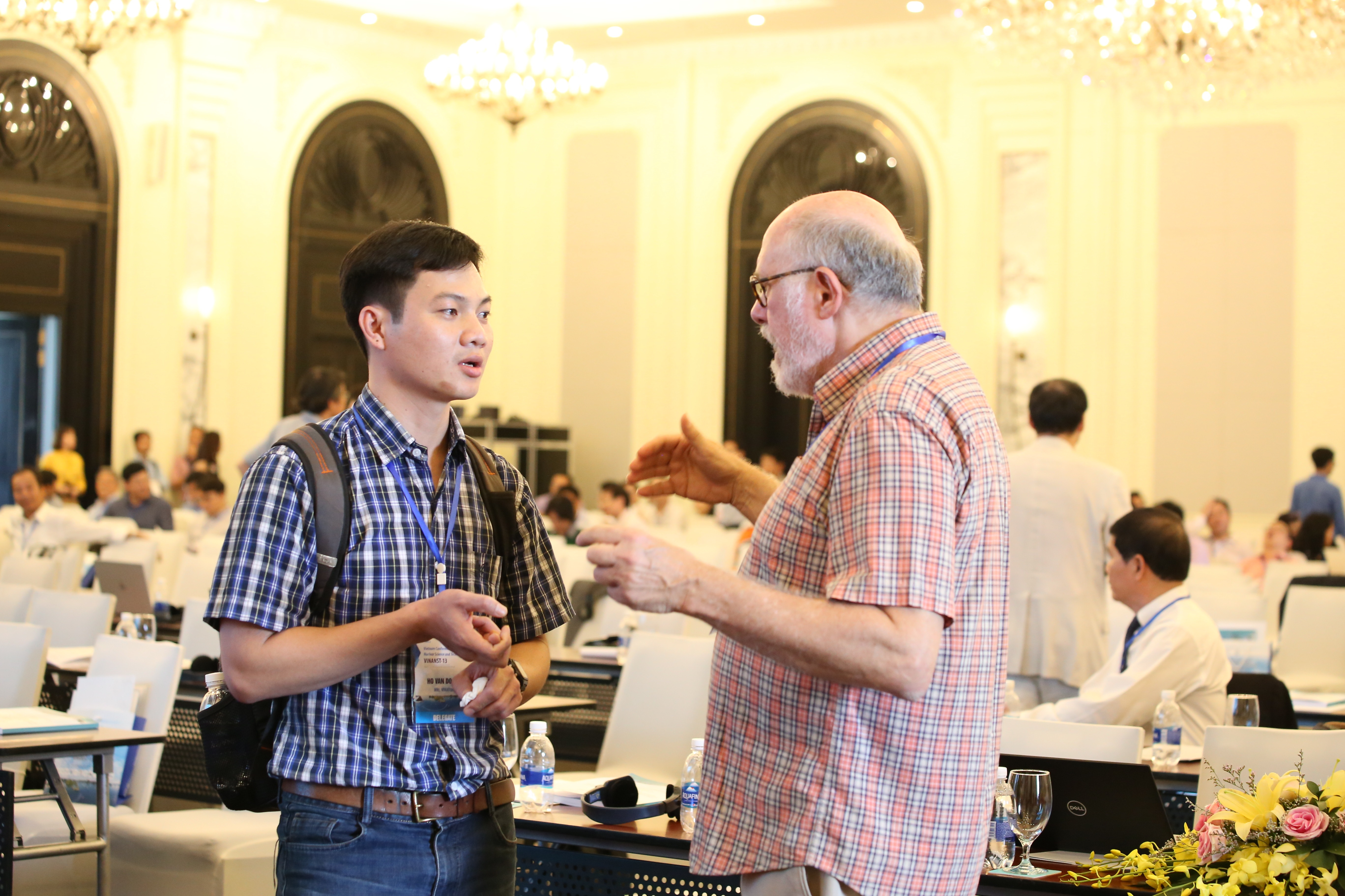 Nhà nghiên cứu trẻ Hồ Văn Doanh (Viện nghiên cứu hạt nhân) trao đổi với giáo sư Sheldon Lansberger (trường Đại học Texas, Mỹ) bên lề Hội nghị.