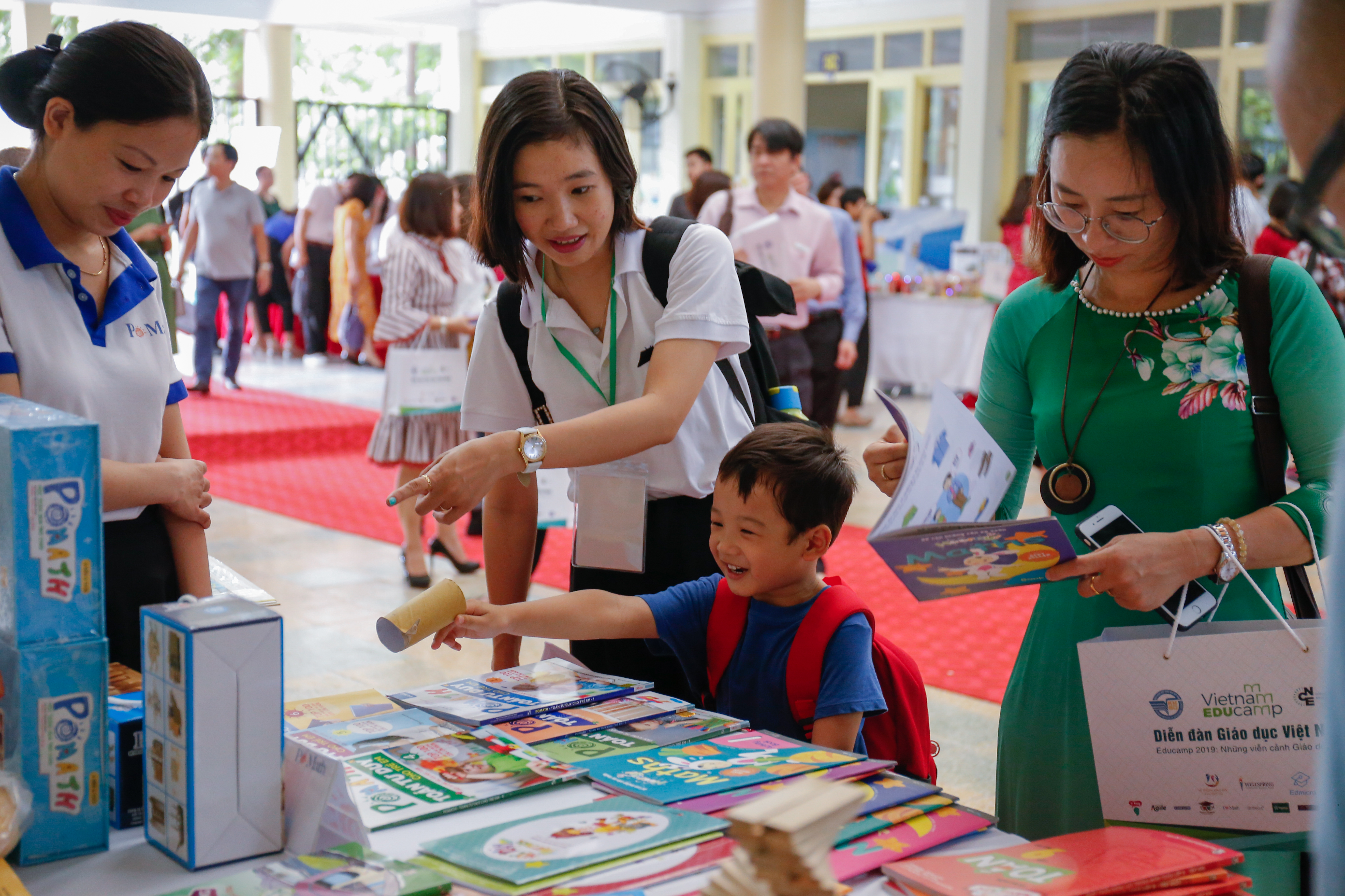 Phụ huynh, học sinh và giáo viên tham khảo sách Toán cho học sinh tiểu học tại khu vực triển lãm Vietnam Educamp 2019. 