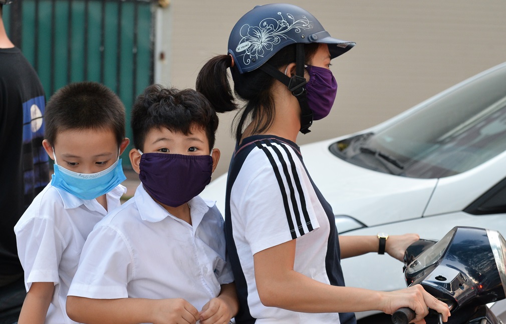 Chất lượng không khí ảnh hưởng đến chất lượng cuộc sống của người dân. Trong ảnh, trẻ em đeo khẩu trang khi ngồi sau xe máy trên đường Nguyễn Đình Thi, Hà Nội chiều 30/9. Ảnh: Việt Hùng/Zing