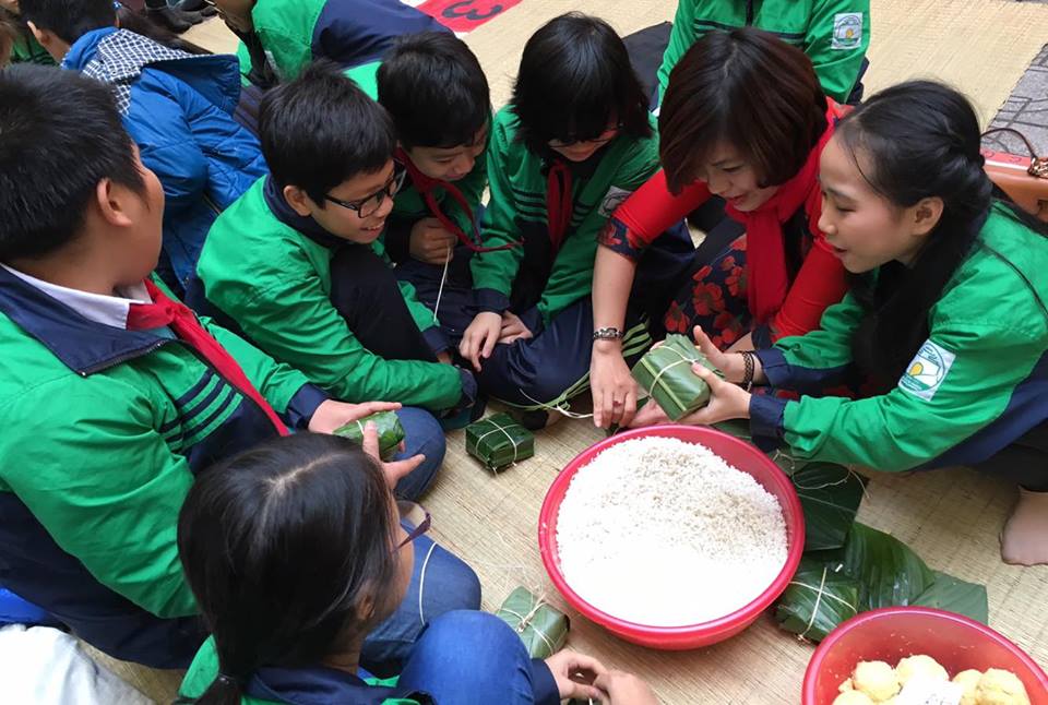 Các em học sinh trường THCS Nguyễn Tri Phương (Ba Đình, Hà Nội) tham gia hoạt động gói bánh chưng gửi tặng trẻ em mồ côi vùng cao Hà Giang. Ảnh: dangcongsan.vn