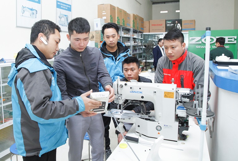 Kỹ thuật viên của Công ty  thiết bị ngành may THSM đang giới thiệu công nghệ cho khách hàng. Ảnh: Nguyễn Khánh/Báo Vĩnh Phúc