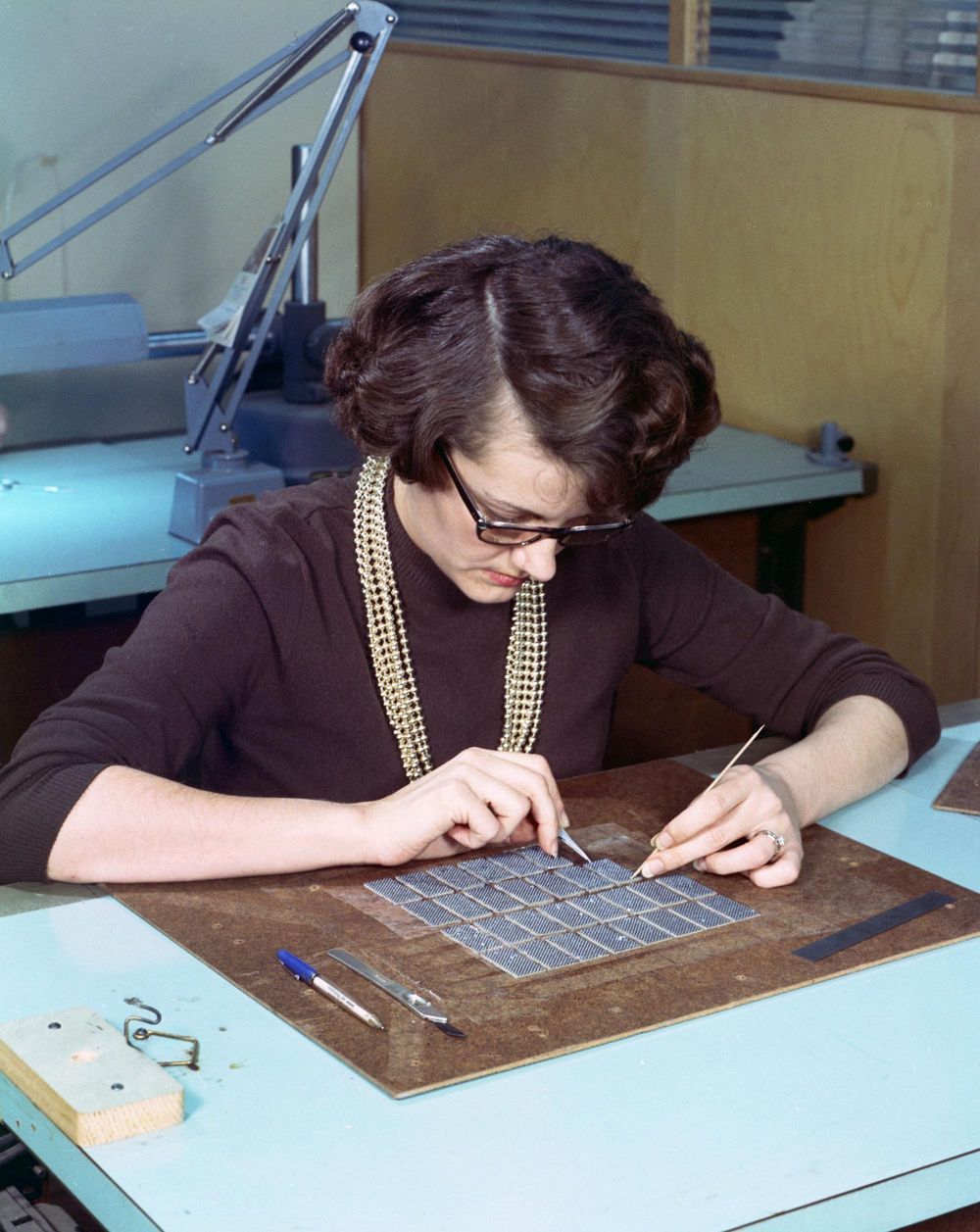 Một phụ nữ đang xâu các bộ phận của bộ nhớ trên máy tính Apollo Guidance Computer. Ảnh: Wikimedia Commons.