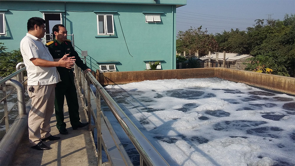 Đại tá Thiều Quốc Hân (bên trái) kiểm tra quá trình xử lý nước thải bằng công nghệ nano tại trạm xử lý nước thải tập trung cụm công nghiệp Quất Động (huyện Thường Tín, TP Hà Nội).