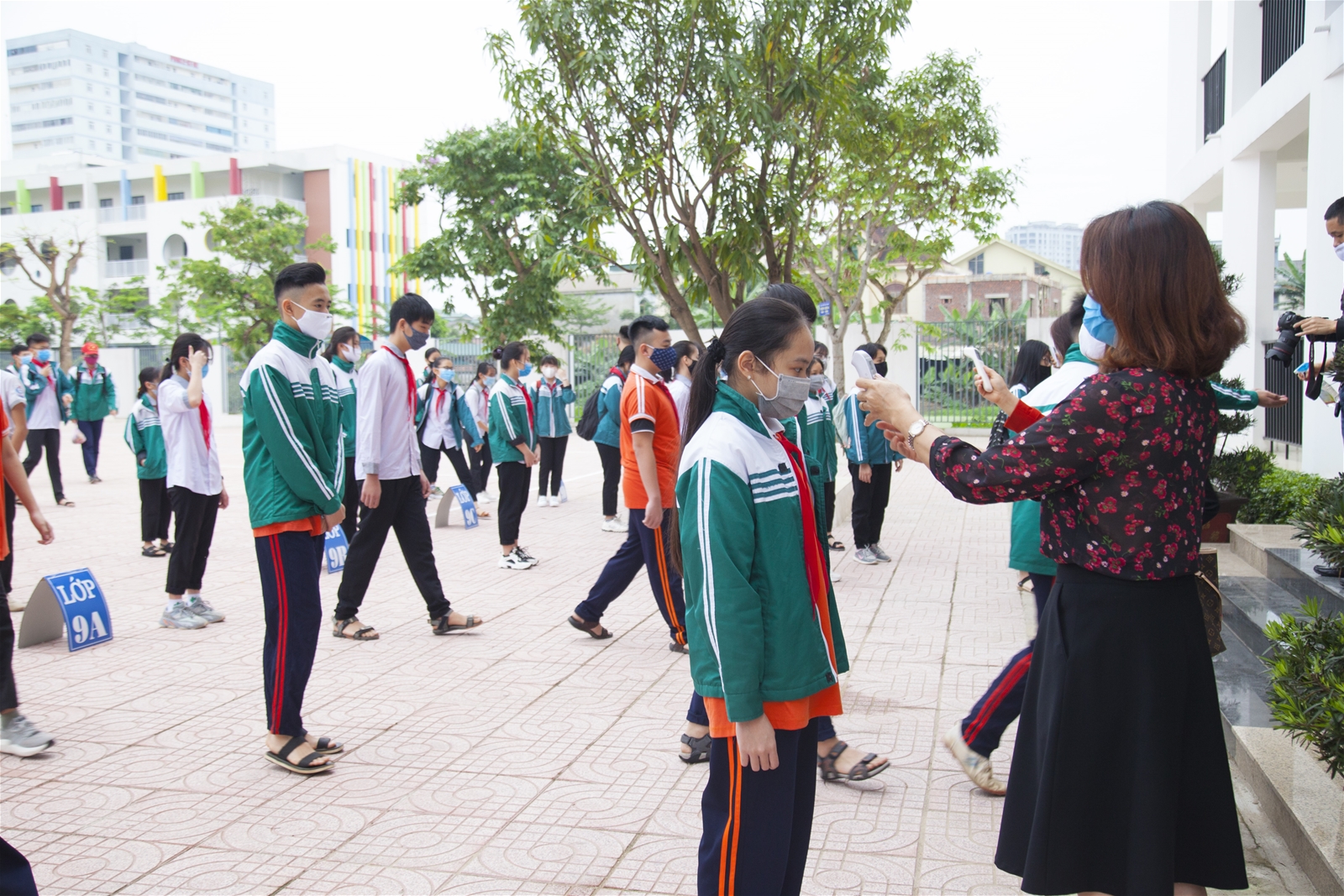 Học sinh Trường THCS Hưng Bình (TP Vinh, Nghệ An) đo thân nhiệt trước khi vào lớp. Ảnh: giaoducthoidai.vn