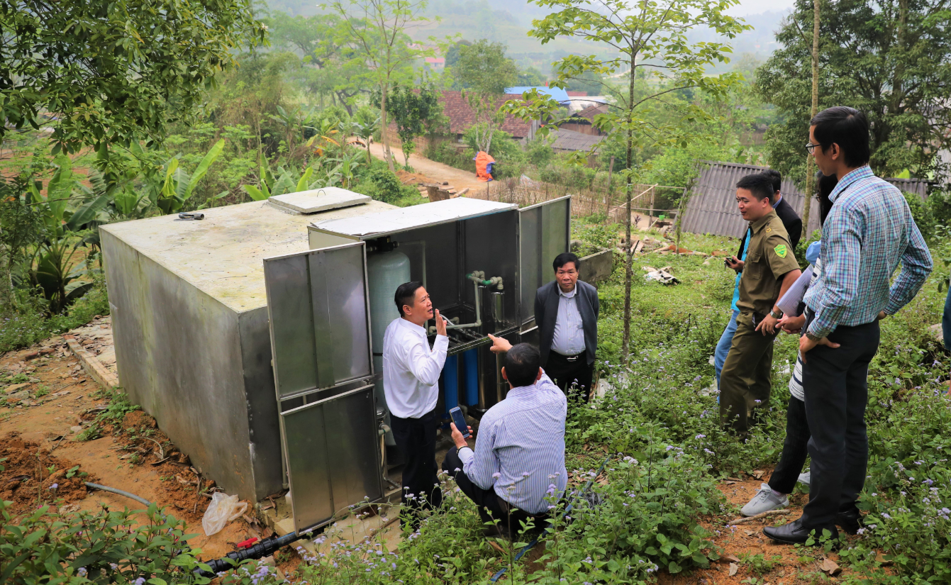 Kiểm tra mô hình thu trữ, xử lý nguồn nước mưa tại trường mầm non Hảo Nghĩa, huyện Na Rì, tỉnh Bắc Kạn. Ảnh: Văn phòng Chương trình Tây Bắc.