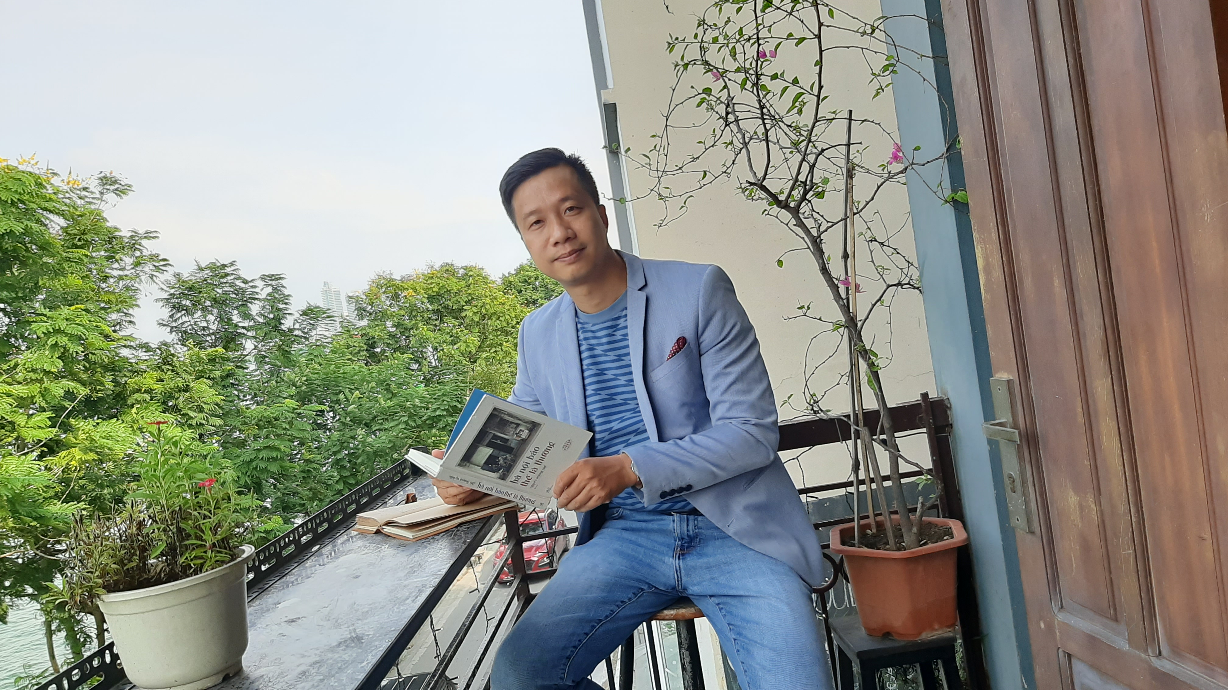 Tác giả Nguyễn Trương Quý bên tác phẩm mới ra mắt – Hà Nội bảo thế là thường. Ảnh: NVCC