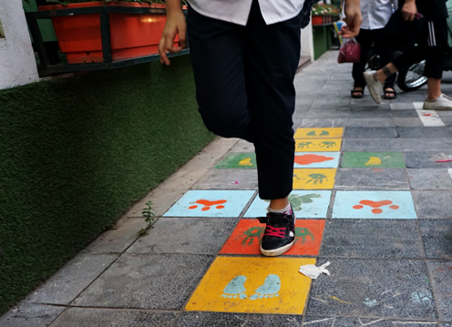Trẻ em thích thú với những hình khối trò chơi dân gian được tạo ra trên đường đến trường