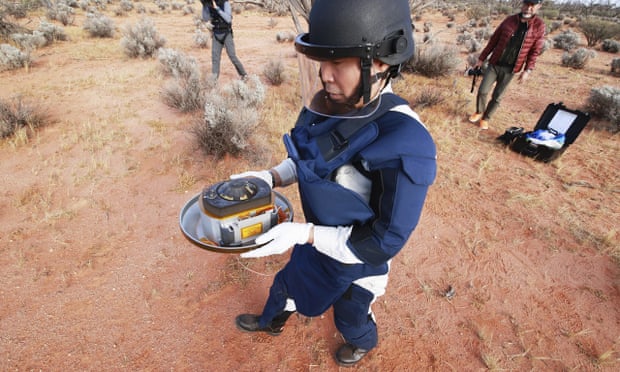 Một thành viên của Cơ quan Thám hiểm Hàng không Vũ trụ Nhật Bản (JAXA) thu mẫu vật tiểu hành tinh do Hayabusa2 thả về ở Úc. Ảnh: theguardian