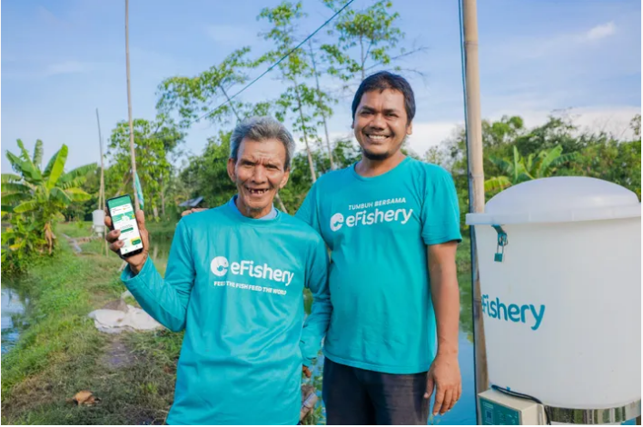 Gibran Hu saifah, nhà đồng sáng lập kiêm CEO của eFishery (phải), bên cạnh một người nuôi cá tra.