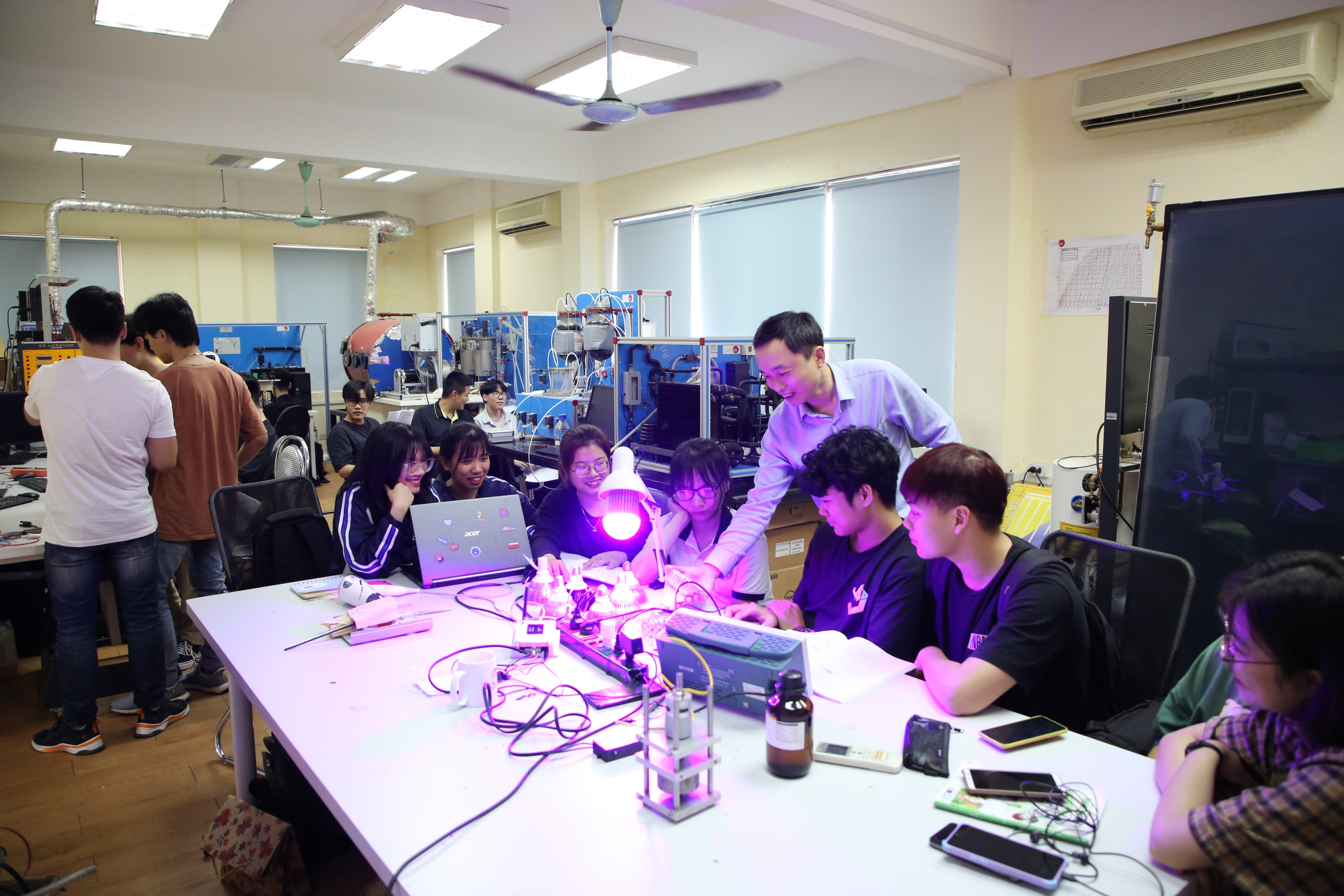 TS Bùi Đình Tú cùng các sinh viên trường ĐH Công nghệ xem xét hệ thống chiếu sáng đèn LED. 