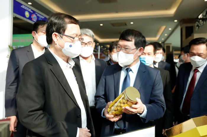 Chủ tịch UBND tỉnh Bắc Giang giới thiệu với Bộ trưởng Bộ KH&CN Huỳnh Thành Đạt sản phẩm trà hoa vàng – một trong những thương hiệu tiêu biểu của Bắc Giang trong khuôn khổ hội nghị SHTT toàn quốc 2022. Ảnh: TA