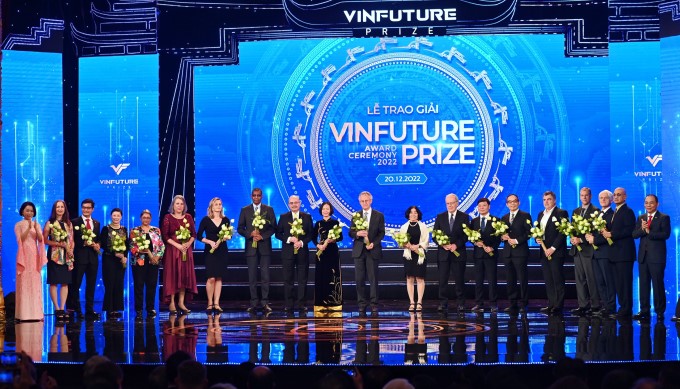 Vợ chồng tỷ phú Phạm Nhật Vượng (bìa trái và phải) tặng hoa cho các thành viên giám khảo trong lễ trao giải mùa 2 tại Nhà hát Lớn Hà Nội, 20/12/2022. Ảnh: Quỹ VinFuture
