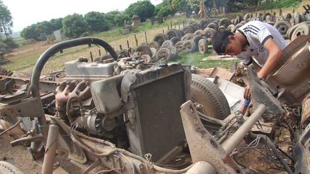 Một người thợ đang "mổ" xe tại thôn Thuyền vào năm 2013. Ảnh: Nhân Dân