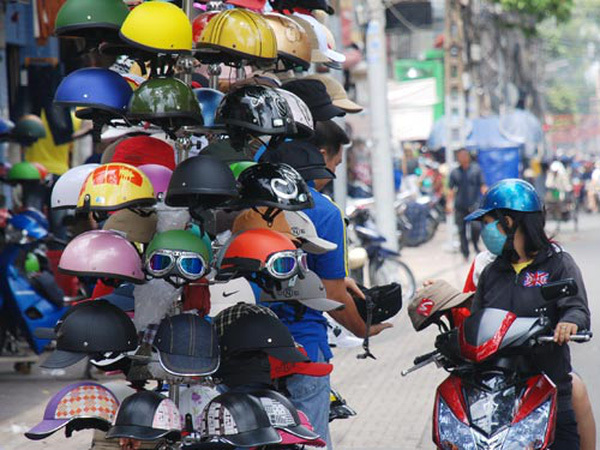Người dân mua mũ bảo hiểm trên đường. Ảnh: baogiaothong.vn